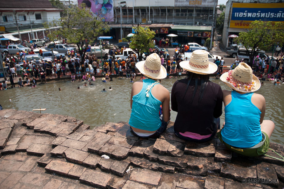 Girls sit above the moat of Chiang Mai, Thailand during the 2006 Songkran Thai New Year Festival.