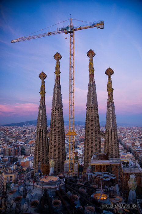 A construction crane rises over the Sagrada Familia Cathedral designed by Antoni Gaudi in Barcelona, Spain.