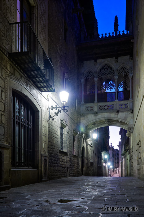 A gothic bridge arches over the Carrer del Bisbe in the Gothic Quarter of Barcelona.