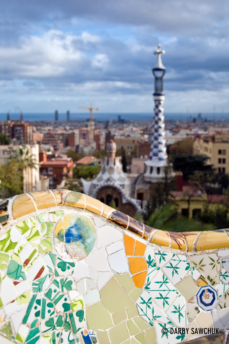 A mosaic-tiled bench on the main terrace of Park Guell looking towards the main entrance.