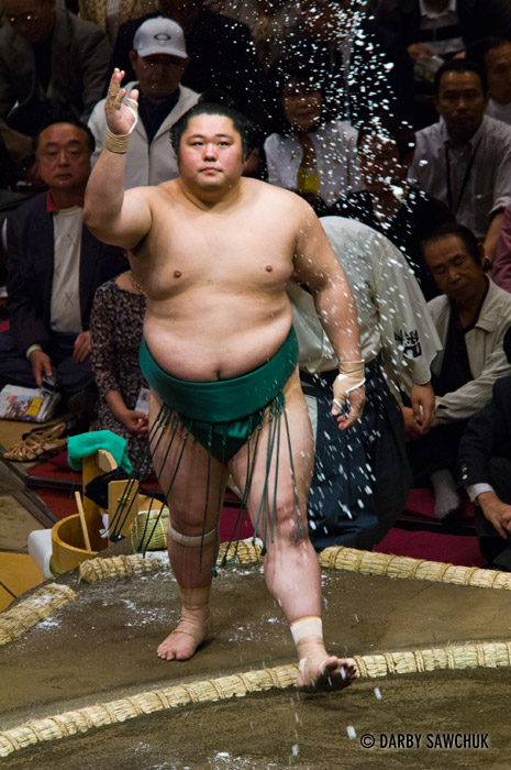 A sumo wrestler tosses salt to purify the ring at the Ryogoku stadium in Tokyo, Japan.