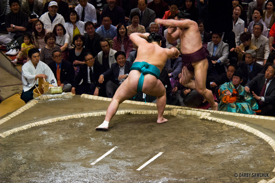 A sumo wrestler is tossed into the crowd at the Ryogoku stadium in Tokyo, Japan.