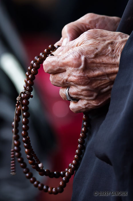 An elderly woman holds prayer beads at Longshan Temple in Taipei.