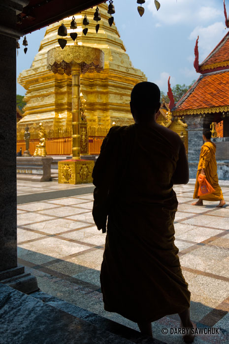 Monks admire a golden chedi at Wat Doi Suthep near Chiang Mai, Thailand.