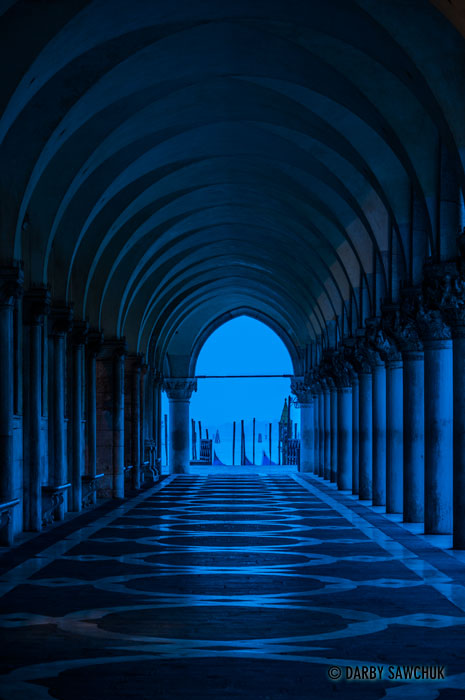 The blue light before dawn filters through the columns supporting the arcade beneath the Doge's Palace in St. Mark's Square.
