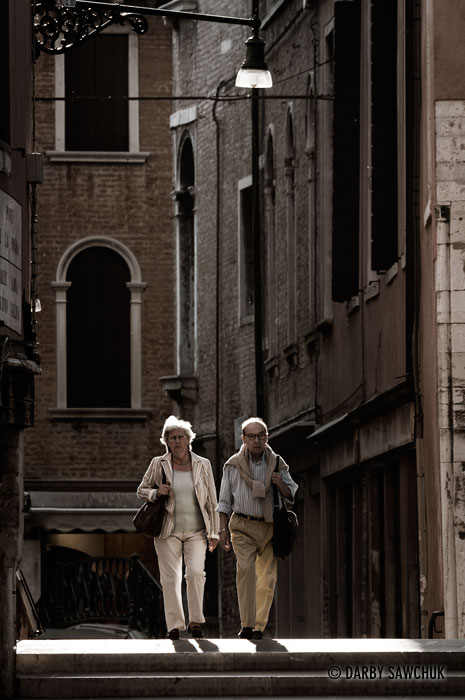 A couple walk over a bridge in the Cannareggio district in Venice, Italy.