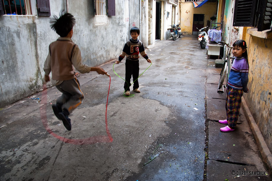 Vietnamese children jump rope and play in an alleyway in the old quarter of Hanoi, Vietnam.