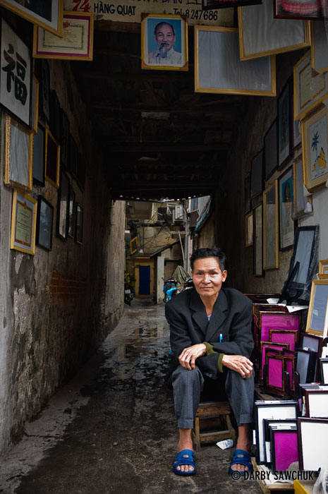 A vendor selling picture frames is one of the many vendors and craftspeople selling their wares out in the open air in Hanoi's old quarter.