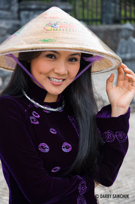 A woman wearing a conical Asian hat poses at the Khai Dinh tomb near Hue, Vietnam.