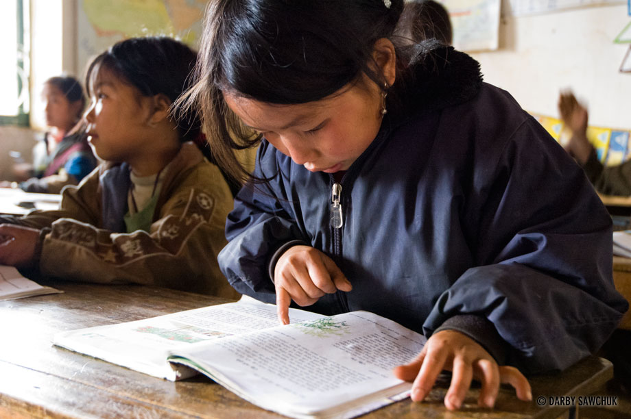 A girl reads her textbook in a school classroom in Sapa, Vietnam.