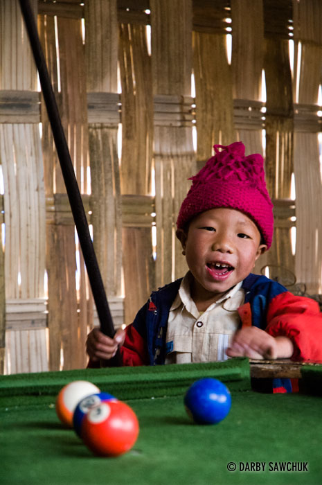 A young boy plays pool in a hut in the village of Ban Ho near the area of Sapa, Vietnam.