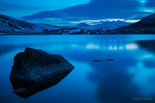 Snowdonia's peaks, including Snowden, Wales' highest peak, viewed from the Llynnau Mymbyr lakes in North Wales, UK.